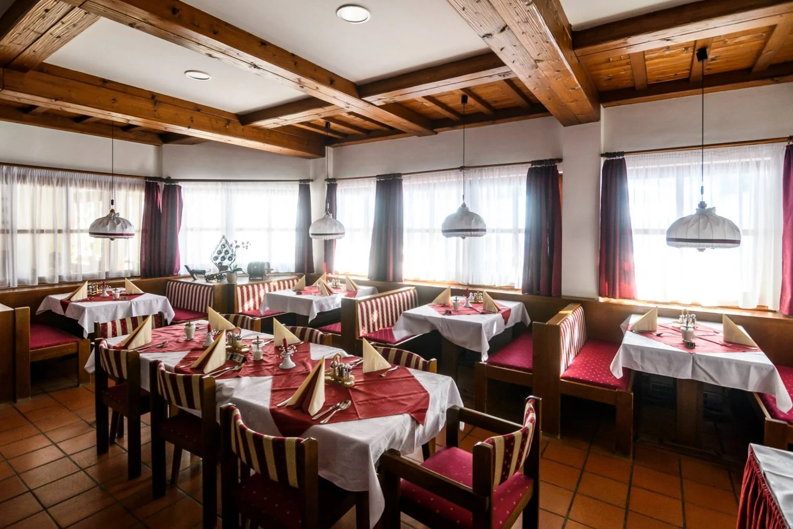 Megterített asztalok a hotel fagerendás étkezőjében