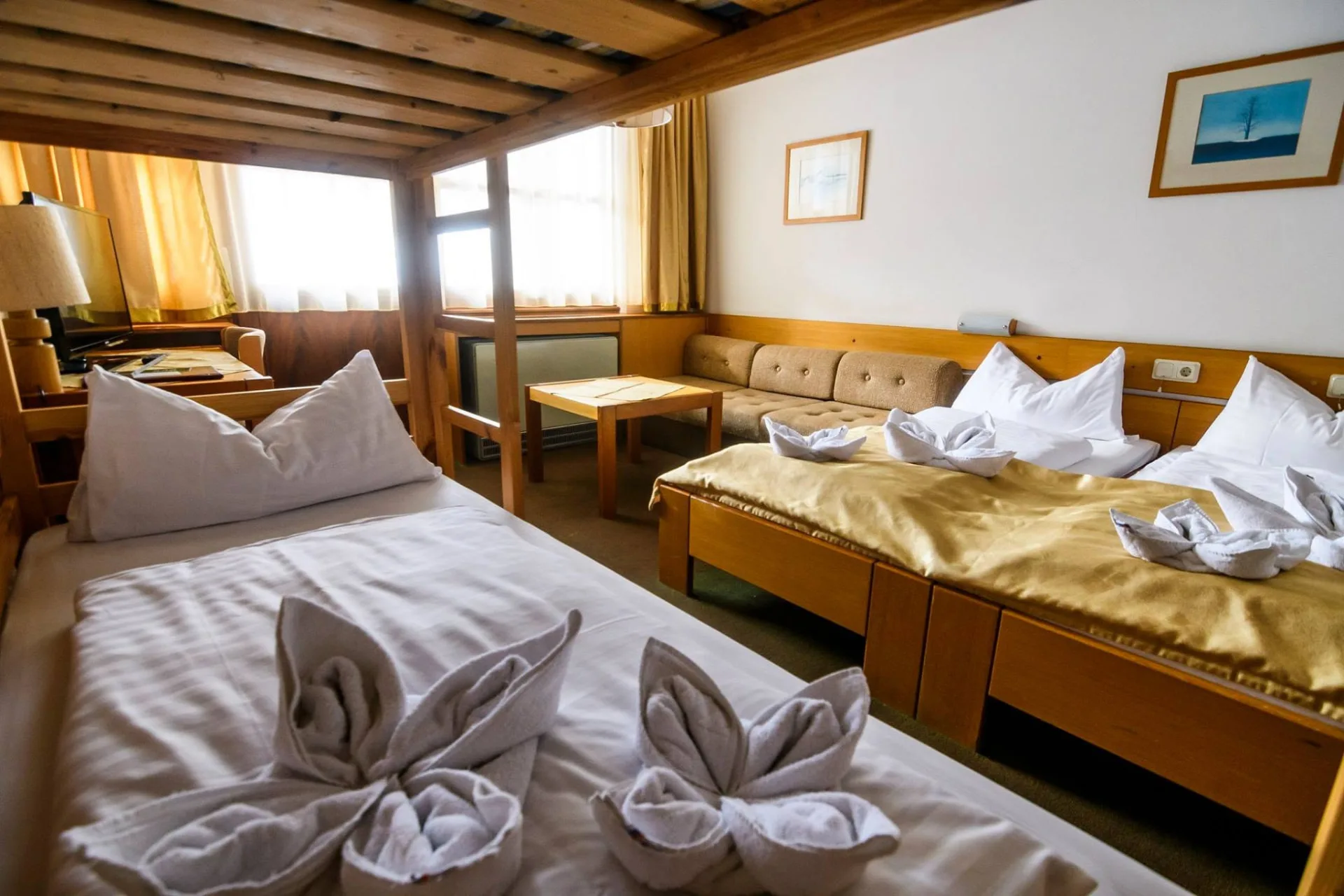 A hotel egyik szobája több ággyal és kanapéval