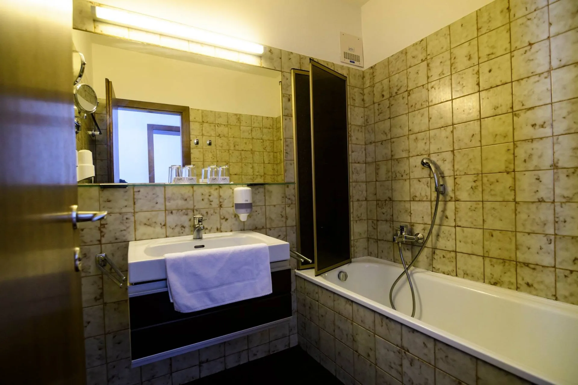 A hotel egyik fürdőszobája káddal és mosdóval