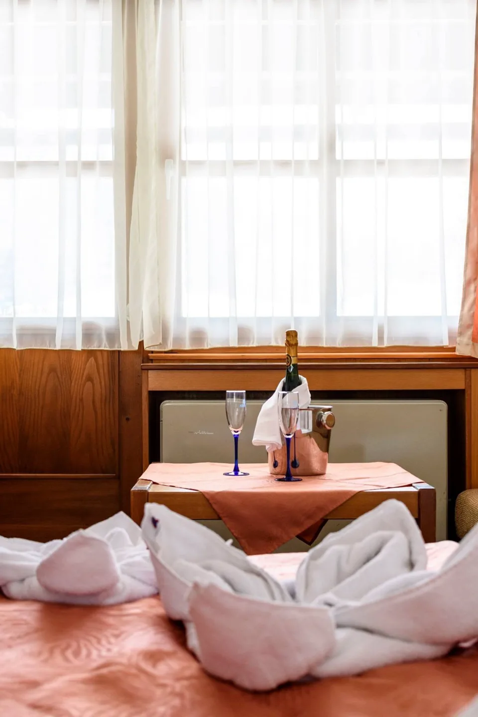 Az ágy törölközőkből hajtott dísszel egy hotelszobában