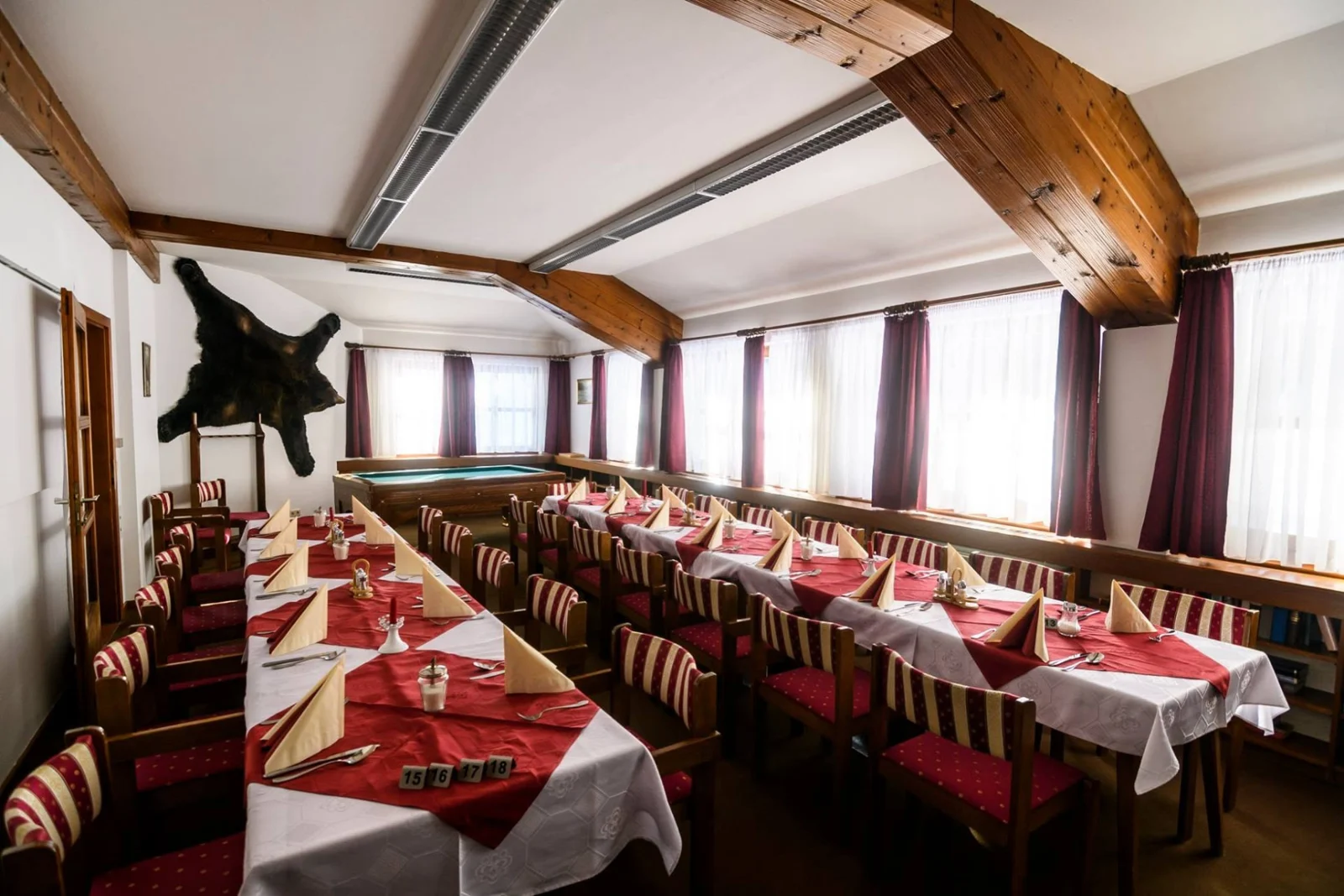 A hotel étkezője megterített asztalokkal és biliárdasztallal